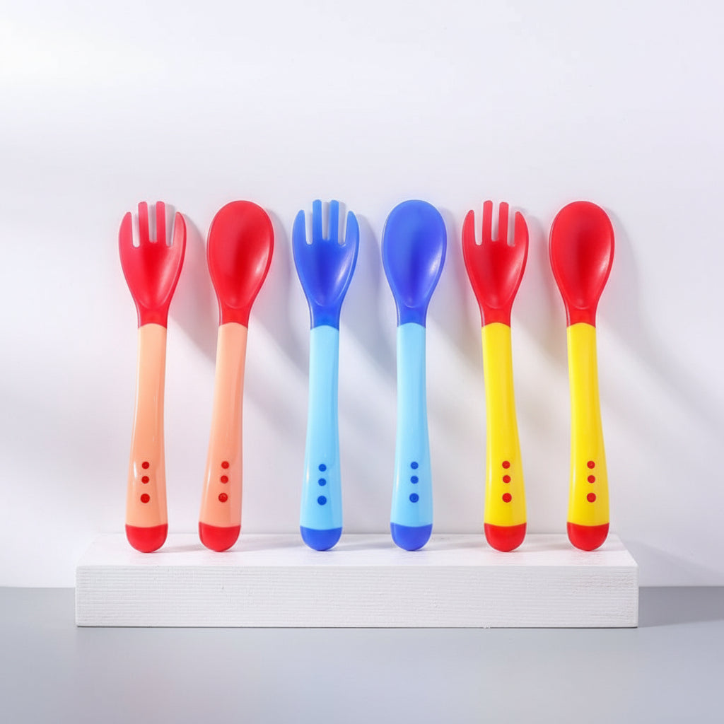 Set of colorful plastic forks and spoons on a light blue background