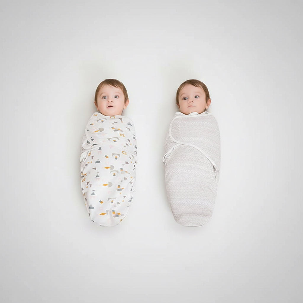 Two babies wrapped in swaddles on a beige carpet